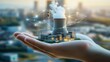 © panumas - Hand holding a small model of a power plant. The model is made of plastic and is placed in a person's hand. Concept of technology and the impact it has on our lives