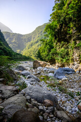 A vibrant blue river flowing through a dramatic mountain canyon, showcasing the stunning natural beauty and dynamic landscape on Shakadang Trail in Taroko National Park, Hualien, Taiwan