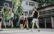 © qunica.com - Friends play basketball at a vintage neighborhood court. The image reflects camaraderie, fitness, and the joy of sports on a sunny afternoon.