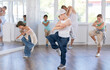 © JackF - Preteen boy performing hip hop dance moves, showcasing skills and concentration, during group class for kids led by young male instructor in street dance studio