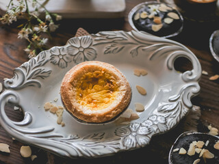 Delicious Traditional Portuguese egg tart in a white plate on the table
