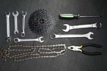 Poster - Parts of bicycle and tools on black table, flat lay