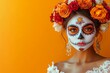 © PixPacks - Attractive woman with day of the dead makeup on orange background