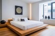 © Sanchai - A modern minimalist bedroom, featuring a low bed with crisp white linens and a few elegant decorative elements