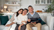 © saksit - Portrait of Loving Asian Family , Mature Asian Parents with Young Daughter on sofa in living room at home