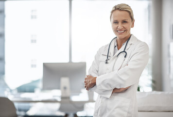 Wall Mural - Doctor, confident and portrait in hospital for healthcare, career path and smile in office space. Mature woman, cardiologist and arms crossed in clinic for friendly service, positivity and trust