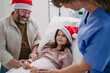 © Halfpoint - Father beside daughter on hospital bed. Sick little girl spending Christmas in hospital Nurse working shift on Christmas Eve.