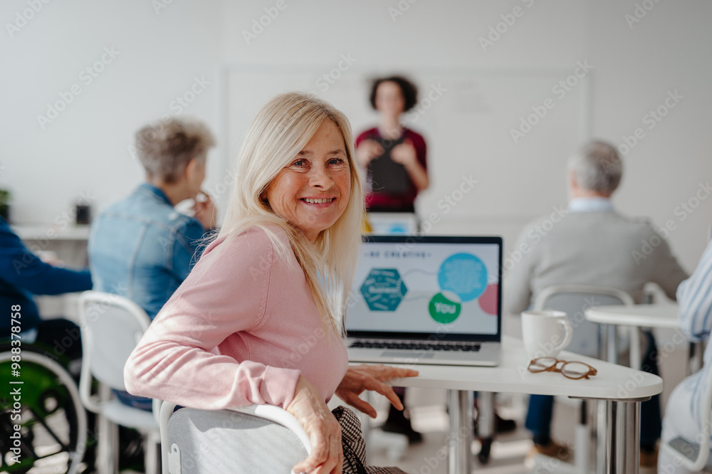 Portrait of female senior student learning how to work with digital ...