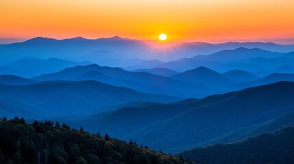 Wall Mural - Stunning sunset over layered blue mountains in the early evening sky