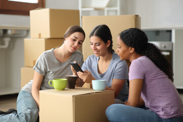 Three roommates checking cell phone moving home