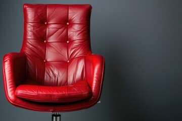 A single red leather chair sitting against a gray background