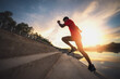 © sutadimages - runner athlete running feet up stair at sunset time.