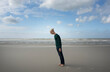 © Westend61 - Boy leaning forward standing on sand at beach