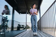 © Westend61 - Young woman standing on balcony with model of wind turbine in hands