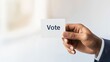 © akarawit - Empowering Voices: A Close-Up of a Hand Holding a Vote Card, Symbolizing Civic Duty and Engaging Communities in the Democratic Process Through Active Participation and Choice.