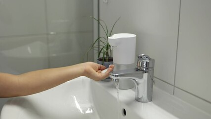 Wall Mural - Little girl wash hands in bathroom. Kid use automatic soap dispenser. Hand with soapy solution closeup