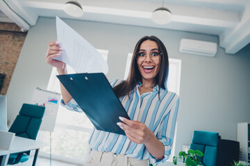 Poster - Photo of professional lovely lady hold paperholder excited resume wear striped formalwear coworking successful businesswoman light office