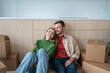 © DimaBerlin - Happy couple man woman hugging dreaming about living in new apartment sitting on floor on kitchen at home. Relocation, moving to flat, family mortgage concept. Spouses enjoying life changes resting.