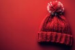 © Маргарита Вайс - winter warm knitted hat with pompom on bright red background top view with copy space