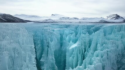 Aufkleber - Vivid blue glacier ice is forming impressive shapes, towering over the frozen landscape with snow covered mountains in the background