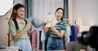 © Johnstocker - Portrait of Two cheerful woman influencers are live streaming sell hats on social media or blogging in home studio. Remote buying, Online shopping, Sell ​​products online