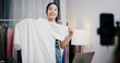 © Johnstocker - Portrait of Cheerful woman influencer is live streaming sell clothes on social media or blogging in home studio. Remote buying, Online shopping, Sell ​​products online
