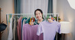 © Johnstocker - Portrait of Cheerful woman influencer is live streaming sell clothes on social media or blogging in home studio. Remote buying, Online shopping, Sell ​​products online