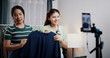© Johnstocker - Portrait of Two cheerful woman influencers are live streaming sell clothes on social media or blogging in home studio. Remote buying, Online shopping, Sell ​​products online
