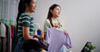 © Johnstocker - Selective focus, Two cheerful woman influencers are live streaming sell clothes on social media or blogging in home studio. Remote buying, Online shopping, Sell ​​products online