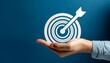 © Galeno - hand holding target representing achieving goals business objective planning