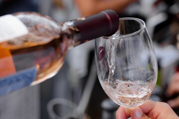 Pouring a glass of wine at an outdoor event