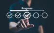 © Supatman - Businessman touches a digital progress checklist with check marks and an advancing loading bar, symbolizing task completion and project progress. progress bar, Management and tracking strategies,