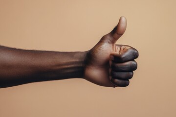 A hand of black man with his thumb up thumbs human approval.