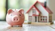 © 69 - Piggy bank beside a model house, representing the process of saving money for a mortgage and future home investment