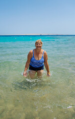 Wall Mural - Woman relaxing on the beach in the sea. Selective focus.