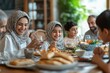 © Lumina Frame - Happy Middle Eastern family shares pita bread at dining table on Ramadan, Generative AI