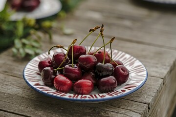 Cherry fruits on white and red ceramic round plate