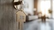 © Martin - The entrance to a new dwelling is displayed with an open door, a key placed in the lock, and a charming home-shaped keychain, representing ideas of property and new home ownership.