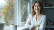 © Jirawatfoto - smiling woman stands by window, showcasing warm and inviting atmosphere. natural light highlights her features, creating cheerful and relaxed vibe