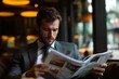 © fotofabrika - A man in a suit reads a newspaper while seated in a cozy café, surrounded by soft lighting in an urban setting