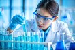 © NeuralStudio - Asian scientist in laboratory carefully conducting an experiment with test tubes wearing protective gear and concentrated on the procedure involving blue liquid chemicals