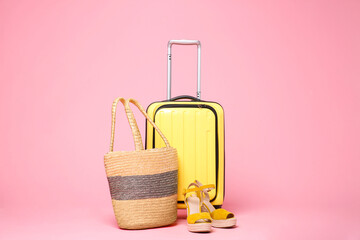 Sticker - Yellow suitcase, wicker bag and shoes on pink background