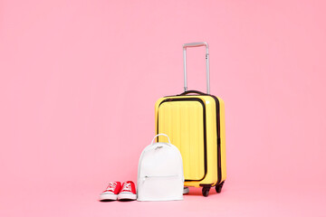 Canvas Print - Yellow suitcase, sneakers and backpack on pink background