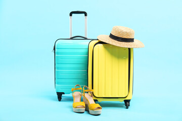 Wall Mural - Suitcases with wicker hat and shoes on light blue background