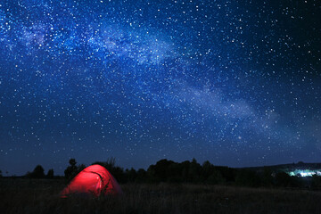 modern camping tent in wilderness at night, slow shutter speed effect