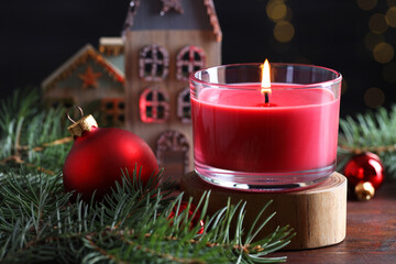 Canvas Print - Burning candle, Christmas decor and fir tree branches on wooden table, closeup