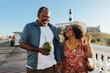 © (JLco) Julia Amaral - Happy senior couple enjoying a relaxed walk on holiday with a coconut drink