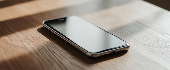 Poster - A modern smartphone rests on a wooden table with light reflecting off the screen.