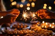 © Dina - close-up of hands holding sparklers, with backdrop of traditional Diwali sweets and snacks arranged on a table. festive spirit and joyous moments shared during the festival