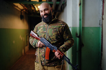 Portrait of the armed bearded man looking with a smiling face straight at the camera